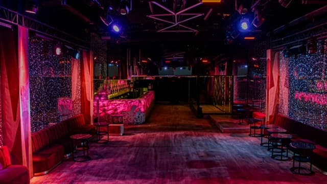 Intérieur de club événementiel avec bar et ambiance lumineuse colorée