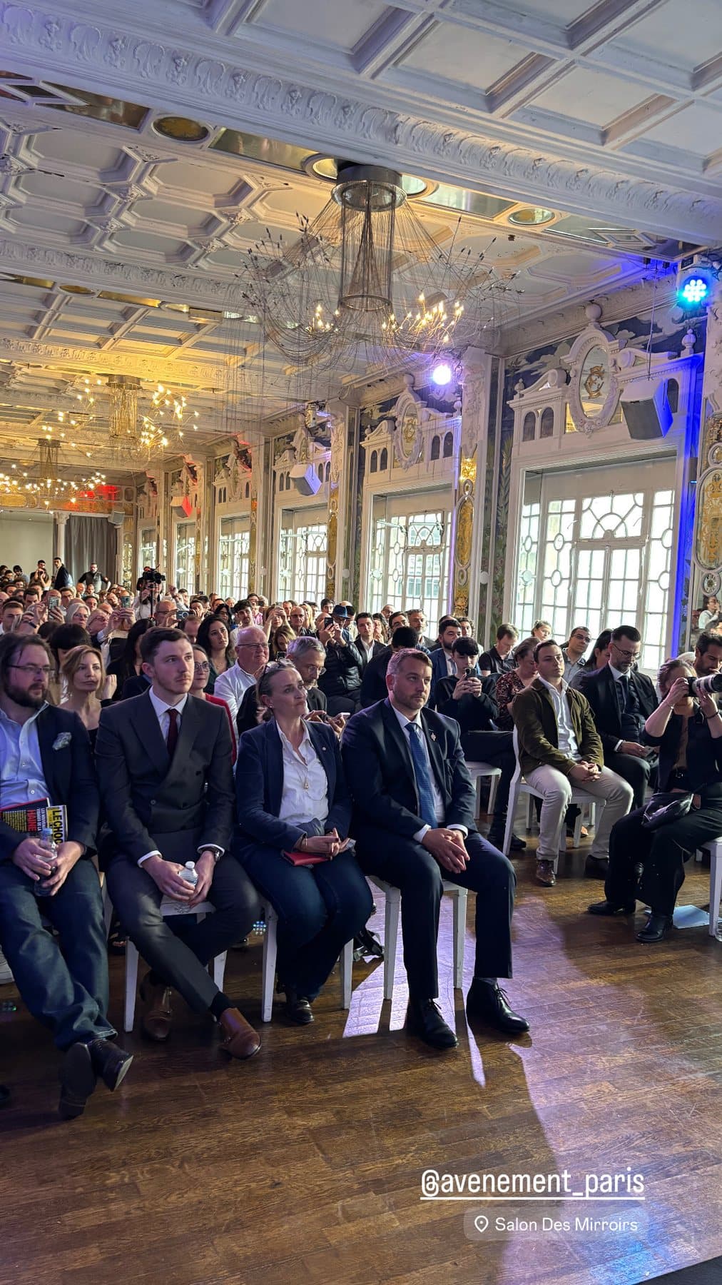 Assemblée assise face à la scène du Salon des Miroirs